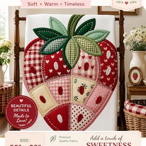 May include: A white quilted throw featuring a large central strawberry design composed of various red, pink, and cream fabric patches with gingham, heart, and floral patterns. The strawberry has green fabric leaves and measures 50 inches by 60 inches.