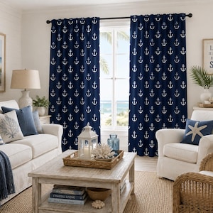 May include: A pair of floor-length curtains in a deep navy blue fabric featuring a repeating white anchor pattern. The curtains are hung on a dark rod and frame a window, with the fabric draped in vertical folds across the window opening.