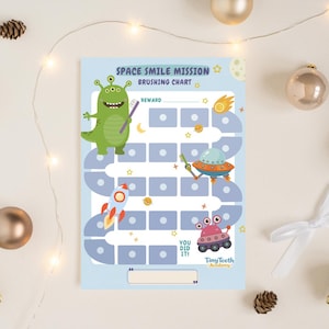 Op de afbeelding: Een lichtblauw "Space Smile Mission" poetskaart met cartoon illustraties van een groene alien, raket en UFO. De kaart heeft vakjes voor beloningen en de tekst "You Did It!"