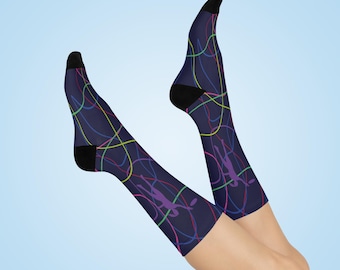 May include: A pair of navy blue socks with black toes and heels. The socks feature a colorful abstract design of curved lines in yellow, green, red, and blue. A purple figure is also visible on the socks.