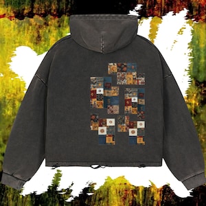 May include: A charcoal gray hooded sweatshirt with a patchwork design on the back. The patchwork features various patterns and colors, including blue, yellow, and red. The sweatshirt has a vintage, worn look.