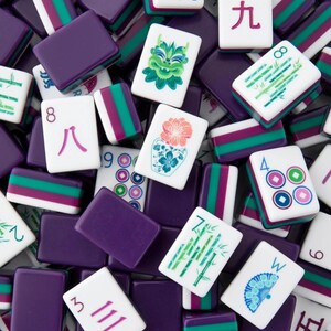 May include: A collection of Mahjong tiles in various colors. The tiles are white with symbols and numbers in red, green, and blue. Purple rectangular tiles are also present, creating a visually rich and engaging composition.