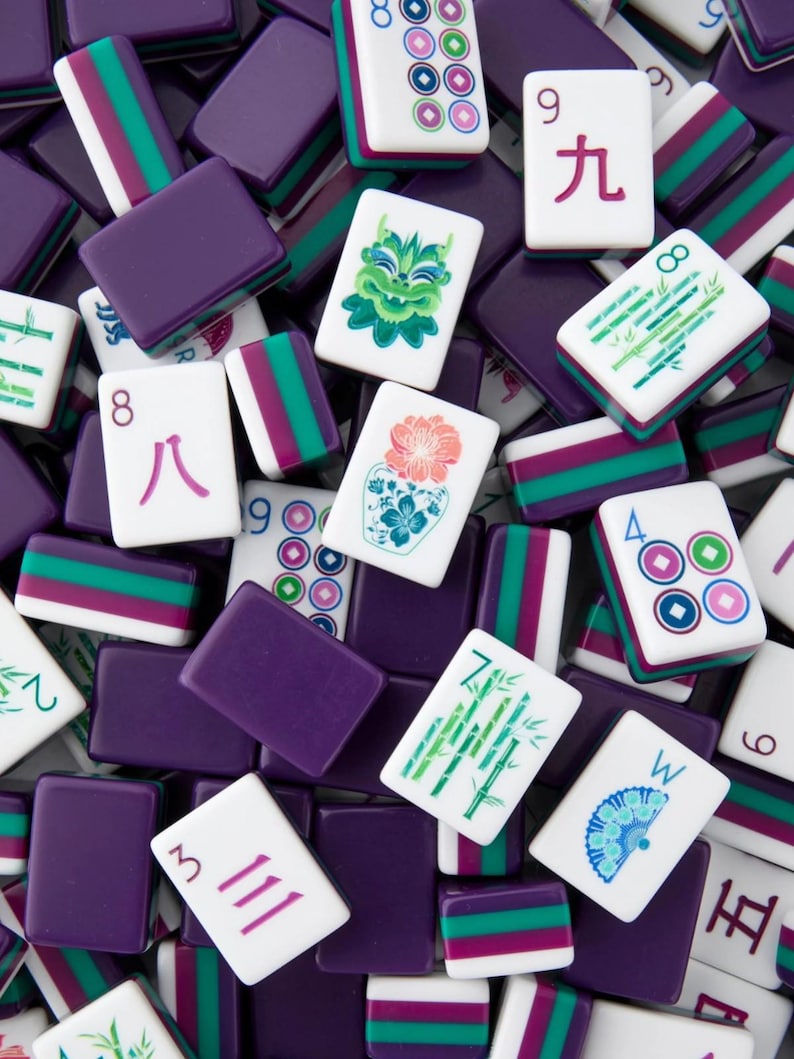 May include: A collection of Mahjong tiles in various colors. The tiles are white with symbols and numbers in red, green, and blue. Purple rectangular tiles are also present, creating a visually rich and engaging composition.