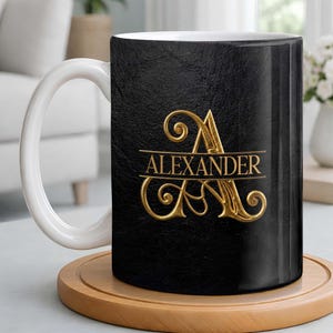 May include: A black coffee mug with a white handle and rim. The mug features the name "Alexander" in gold script, with a decorative initial "A". The mug sits on a round wooden coaster.