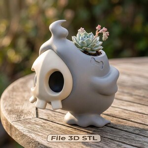 Könnte beinhalten: Ein grauer, schädelformiger Pflanztopf mit einer Sukkulentenpflanze. Der Topf hat ein knochenförmiges Detail und ein hellbraunes Schädelgesicht. Der Text "File 3D STL" befindet sich unten. Der Topf steht auf einer Holzoberfläche.