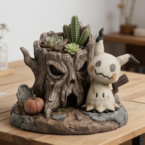 Op de afbeelding: Een gedetailleerde harsplanter in de vorm van een spookachtige boomstronk met een gesneden gezicht, met vetplanten en cactussen. Een Mimikyu-figuur staat ernaast, met een kleine grafsteen en pompoen. De planter is ongeveer 20 cm breed.