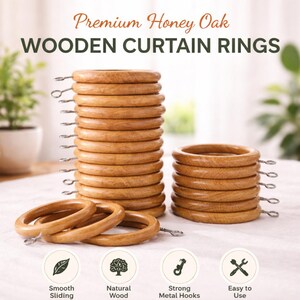 Puede incluir: Una colección de anillas para cortinas de madera de roble color miel con ganchos metálicos. La imagen muestra una pila alta de anillas, una pila más corta y tres anillas sueltas. El texto dice Premium Honey Oak WOODEN CURTAIN RINGS, Smooth Sliding, Natural Wood, Strong Metal Hooks, Easy to Use.