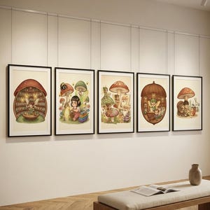 May include: Five framed art prints featuring whimsical illustrations of mushroom houses and fairy-like characters. Each print has a black frame and depicts a different scene with vibrant colors and detailed artwork. The prints are displayed on a white wall above a wooden bench.