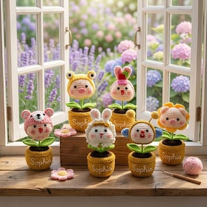 Puede incluir: Una colección de muñecos de macetas de ganchillo hechos a mano, cada uno con una cara de animal diferente: oso, conejo, rana, abeja y cerdo. Las macetas son amarillas y tienen el nombre "Sophia". El fondo muestra una ventana con vistas al jardín.