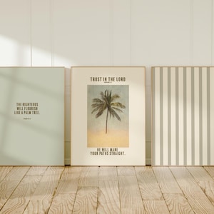 May include: Three rectangular wall art prints. The left print is sage green with black text reading The Righteous Will Flourish Like A Palm Tree. The centre print is cream with a palm tree image and text. The right print has vertical stripes.