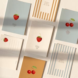 Könnte beinhalten: Eine Sammlung rechteckiger Grußkarten mit Illustrationen von roten Erdbeeren und Kirschen. Einige Karten zeigen Texte wie The fruit of the Spirit is love, joy, peace, Taste and see that the Lord is good und How sweet are your words to my taste.