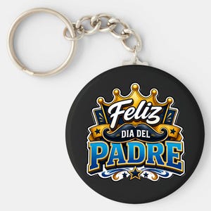 May include: A black keychain with a silver ring and chain. The round pendant features the words "Feliz Dia Del Padre" in blue and gold, with a crown and mustache design.