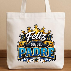 May include: A white tote bag with a colorful graphic design. The design features the words "Feliz Dia Del Padre" in blue and gold, with a crown and mustache. The bag has two white handles.
