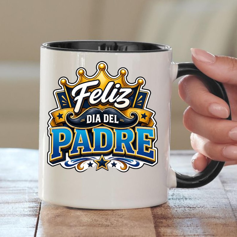 May include: White ceramic mug with a black handle and rim. The mug features the text "Feliz Dia Del Padre" in blue and gold, with a crown and mustache design. A perfect gift for Father's Day.