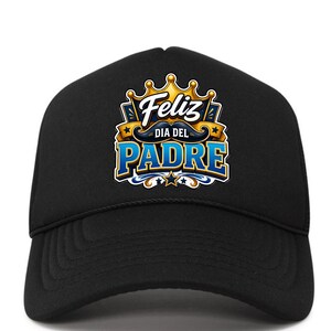 May include: Black trucker hat with a colorful graphic that says "Feliz Dia Del Padre" in blue and gold. The design includes a crown, stars, and a mustache. The hat has a curved brim and a mesh back.