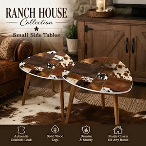 May include: Two side tables with triangular tops featuring a patchwork design of brown, white, and black cowhide patterns. Each table is supported by three tapered, light-colored wooden legs. The tables are displayed together as a set.