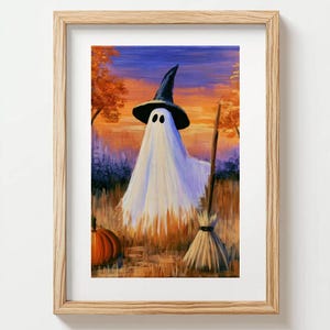 May include: A framed painting depicting a white ghost wearing a black witch hat standing in a field of tall grass at sunset. An orange pumpkin sits to the left, and a wooden broomstick stands upright to the right against a colorful sky.