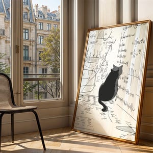 Op de afbeelding: Een ingelijst kunstwerk met een gouden lijst, met een zwarte kat die naar wiskundige vergelijkingen kijkt. Het kunstwerk leunt tegen een muur. Een zwarte stoel met een geweven zitting staat op de voorgrond, bij een raam.