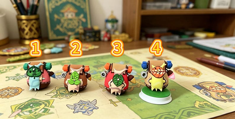 May include: Four colorful, miniature figurines with backpack designs are displayed on a patterned surface. Each figure has a unique color scheme, including red, brown, and blue, with leaf and face details. The figurines are numbered 1 through 4.
