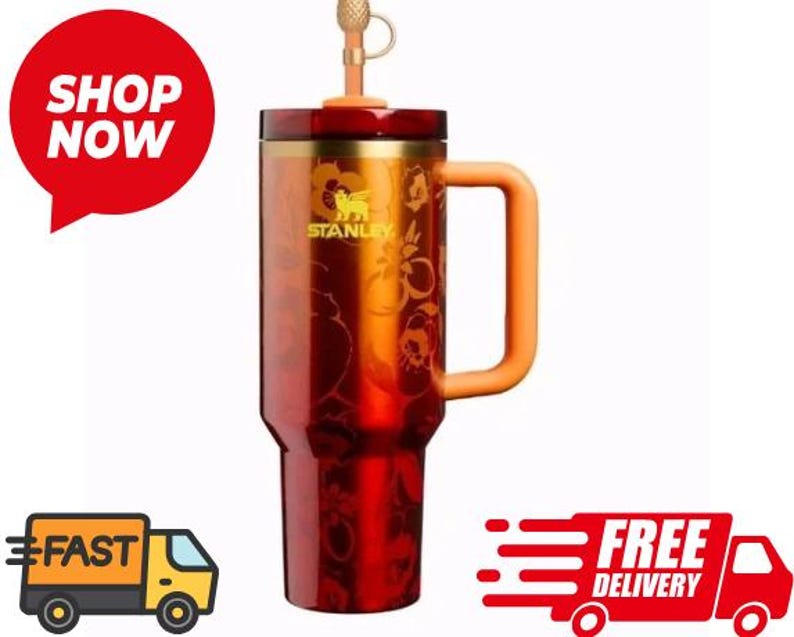 May include: A red and gold Stanley tumbler with a handle and a straw. The tumbler has a floral design and the Stanley logo. The tumbler is designed to keep drinks hot or cold. The tumbler is approximately 9 inches tall.
