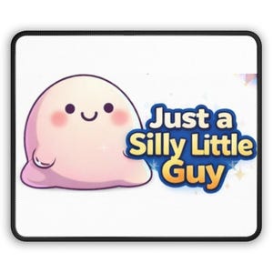 May include: A white mousepad with a black border. It features a cartoon blob character in light pink with a smiling face and a small arm. The text "Just a Silly Little Guy" is in a blue and yellow design.