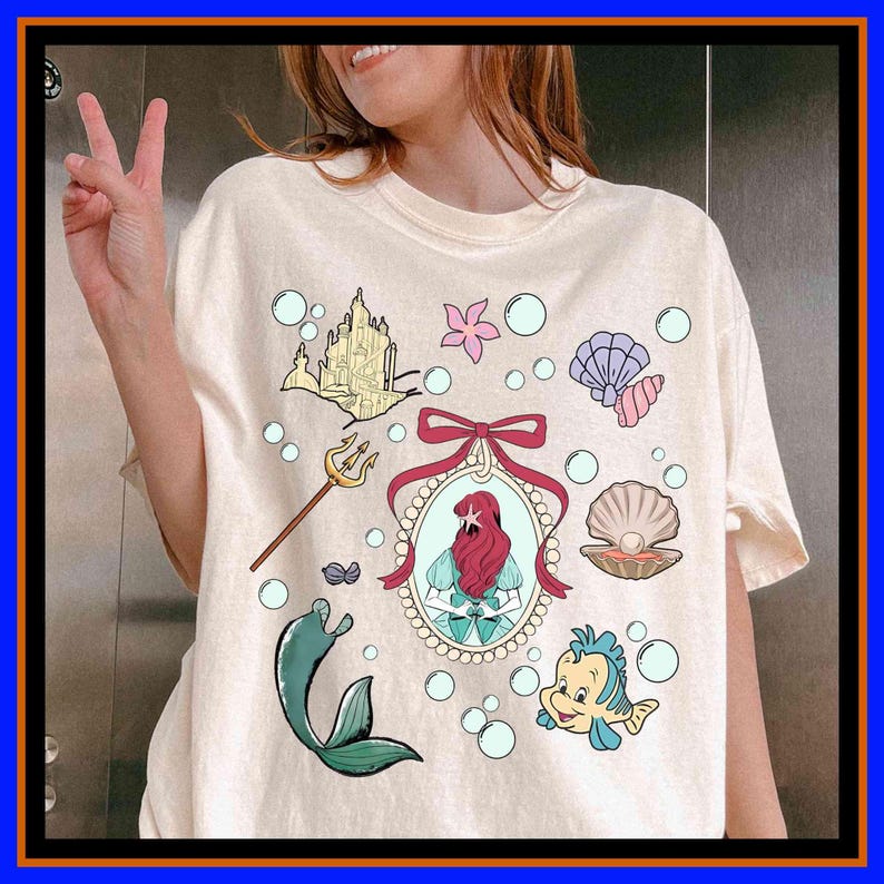 Unisex graphic tee featuring a mermaid princess, seashell, ocean castle, and underwater fantasy design, perfect for kids, adults, matching family outfits, vacations, and fairytale gifts.