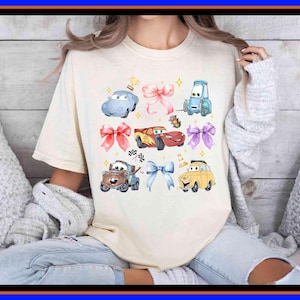 Unisex graphic tee featuring Disney Cars characters in a cute bow-themed collage with Lightning McQueen and friends, perfect for Disney fans, kids, adults, family trip outfits, and gift ideas.