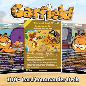 May include: A collection of three custom trading cards featuring Garfield characters. The center card shows Odie and Garfield as pirates on a beach. The left card depicts Garfield with lasagna, and the right card shows Garfield near a television. The text Garfield and 100+ Card Commander Deck is visible.