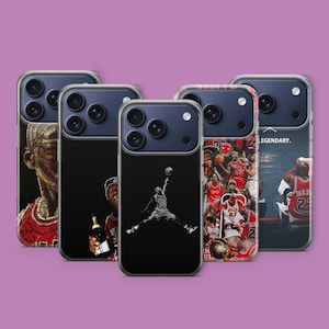 Pode incluir: Cinco capas de telefone com vários designs. Uma capa apresenta uma imagem a preto e branco de um jogador de basquete no ar, outra tem uma colagem de jogadores de basquete e outras têm retratos. As capas têm uma borda transparente e uma estrutura de câmera azul escuro.