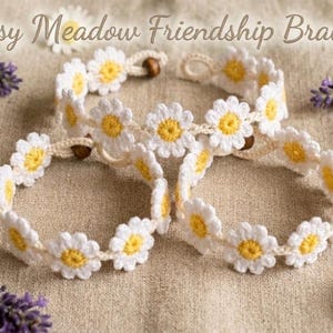 May include: Three handmade crochet friendship bracelets featuring a repeating daisy flower pattern with white petals and yellow centers. Each bracelet includes a small brown wooden bead closure. The text Daisy Meadow Friendship Bracelet is visible.