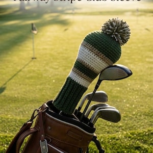 May include: A crochet golf club head cover featuring horizontal stripes in dark green, white, and tan, topped with a multi-colored pom-pom. The cover is placed on a golf club inside a brown leather bag. Text reads: Fairway Stripe Club Sleeve and Happy father's day.