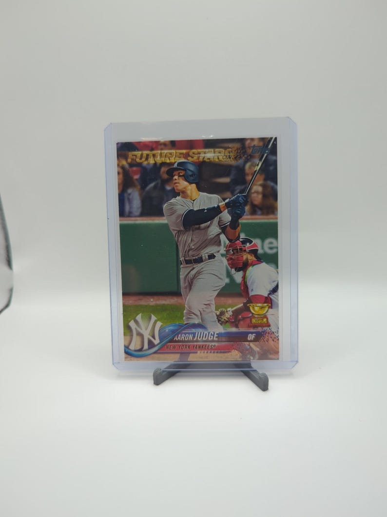 May include: A baseball card featuring Aaron Judge of the New York Yankees in a batting stance. The card is labeled "Future Stars" and is encased in a protective sleeve. The Yankees logo is visible.