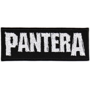 May include: Black rectangular patch with the word "PANTERA" embroidered in white block letters. The patch has a black border and is likely designed to be sewn or ironed onto clothing or accessories.