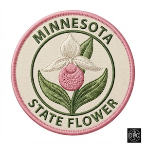 May include: A circular embroidered patch featuring a pink and white lady slipper flower in the center. The text MINNESOTA STATE FLOWER is stitched in dark green around the flower. The patch has a cream background and a pink stitched border.