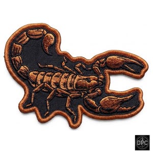 May include: An embroidered patch featuring a scorpion design in shades of copper and brown against a black background. The scorpion is depicted with its tail curved upward and pincers extended, finished with a matching copper-colored stitched border.