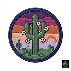 May include: A circular embroidered patch featuring a green saguaro cactus with soccer balls hanging from its arms against a desert landscape. The background displays layers of purple, pink, and orange sky with a setting sun and smaller cacti.