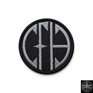 May include: A circular embroidered patch featuring a black background with a silver-grey stitched monogram design. The design consists of the letters C, F, and A intertwined within a circular border, all rendered in a clean, uniform embroidery stitch.