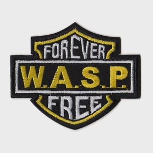 Puede incluir: Parche bordado con fondo negro y forma de escudo. El parche presenta las palabras "FOREVER" y "FREE" en blanco, y "W.A.S.P." en amarillo. El parche está contorneado en amarillo y blanco.