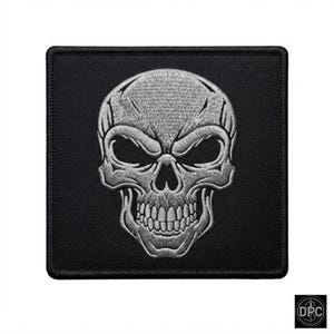 Könnte beinhalten: Ein quadratischer, bestickter Aufnäher mit einem silberfarbenen Totenkopfmotiv auf schwarzem Hintergrund. Der Totenkopf ist mit detaillierten Stickereien versehen, die die Augenhöhlen, die Nasenhöhle und die Zähne auf dem dunklen Stoff betonen.