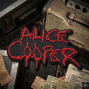 May include: An embroidered patch featuring the text Alice Cooper in bold red thread with a black border. The lettering has a jagged, dripping style. The patch is displayed against a dark, textured background with vintage concert tickets and gear.