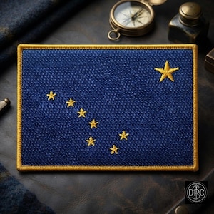 May include: A rectangular embroidered patch featuring a deep blue fabric background with eight gold-colored stars arranged to represent the Big Dipper and the North Star, all enclosed within a thick, stitched gold-colored border.