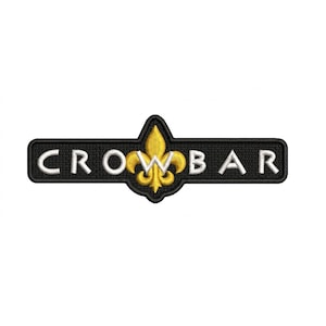 Könnte beinhalten: Ein schwarzer, gestickter Aufnäher mit dem Wort "CROWBAR" in weißen Großbuchstaben. Ein goldenes Fleur-de-Lis-Design befindet sich mittig über dem Wort. Der Aufnäher ist rechteckig mit abgerundeten Ecken.