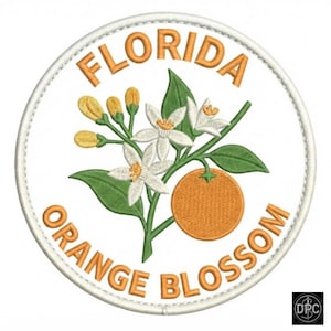 May include: A circular embroidered patch with a white background and a stitched border. The design features a central orange fruit, green leaves, and white orange blossoms with yellow buds. The text FLORIDA ORANGE BLOSSOM is stitched in orange.