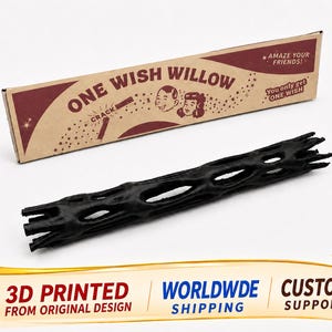 May include: A black, cylindrical, hollow object with a lattice-like structure, accompanied by a rectangular cardboard box labeled ONE WISH WILLOW with illustrations of two faces and the text AMAZE YOUR FRIENDS and You only get ONE WISH.