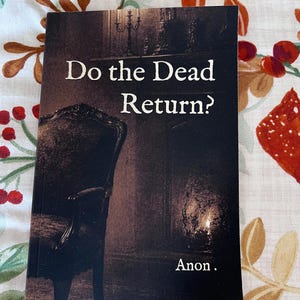 Op de afbeelding: Boekomslag met de titel "Do the Dead Return?" in witte tekst. De omslag toont een donkere, sepia-getinte afbeelding van een kamer met een stoel en een kaars. De auteur staat vermeld als "Anon."