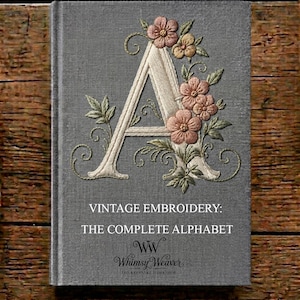 Puede incluir: Un libro de tapa dura gris titulado VINTAGE EMBROIDERY: THE COMPLETE ALPHABET de Whimsy Weaver. La portada presenta una letra A bordada de color crema, decorada con flores rosas y melocotón y hojas verdes con detalles de enredaderas.