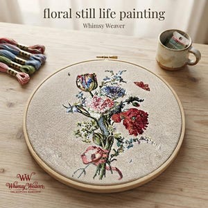 Könnte beinhalten: Ein runder hölzerner Stickrahmen mit einem beigen Stoffeinsatz, der ein detailliertes Blumenstillleben in Rot-, Rosa- und Blautönen zeigt. Über dem Stickrahmen steht der Text "floral still life painting" sowie der Schriftzug "Whimsy Weaver".