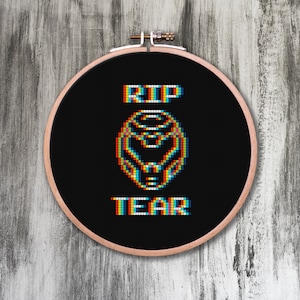 Op de afbeelding: Een zwarte borduurring met een witte gepixelde afbeelding van een videogamepersonage en de tekst "RIP TEAR".