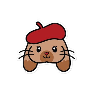Könnte beinhalten: Ein Aufkleber mit einem Cartoon-Hasen, der einen roten Barett trägt. Der Hase hat braunes Fell, schwarze Schnurrhaare und eine herzförmige Nase. Der Aufkleber hat einen weißen Rand.