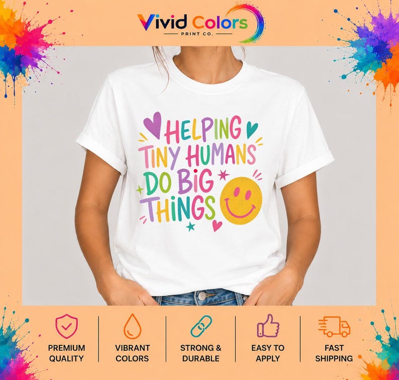 May include: A white short-sleeved t-shirt featuring the colorful text "HELPING TINY HUMANS DO BIG THINGS" in various fonts and shades of pink, yellow, teal, and purple, accompanied by a yellow smiley face icon and small heart and star accents.